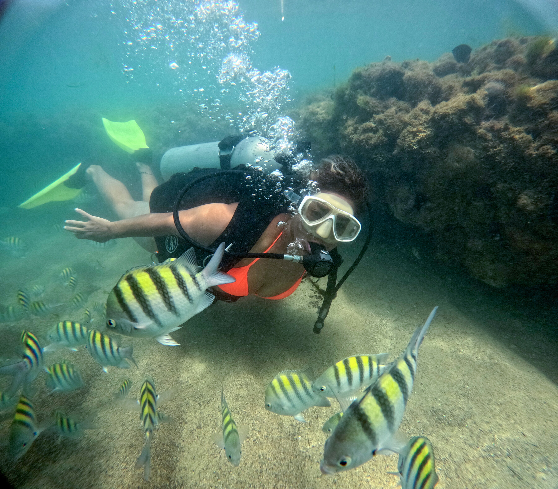 Mergulhadora com equipamento completo explorando os recifes de coral de Pajuçara